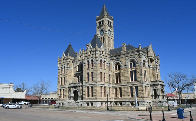Historic Texas courthouse with clock tower under a clear blue sky